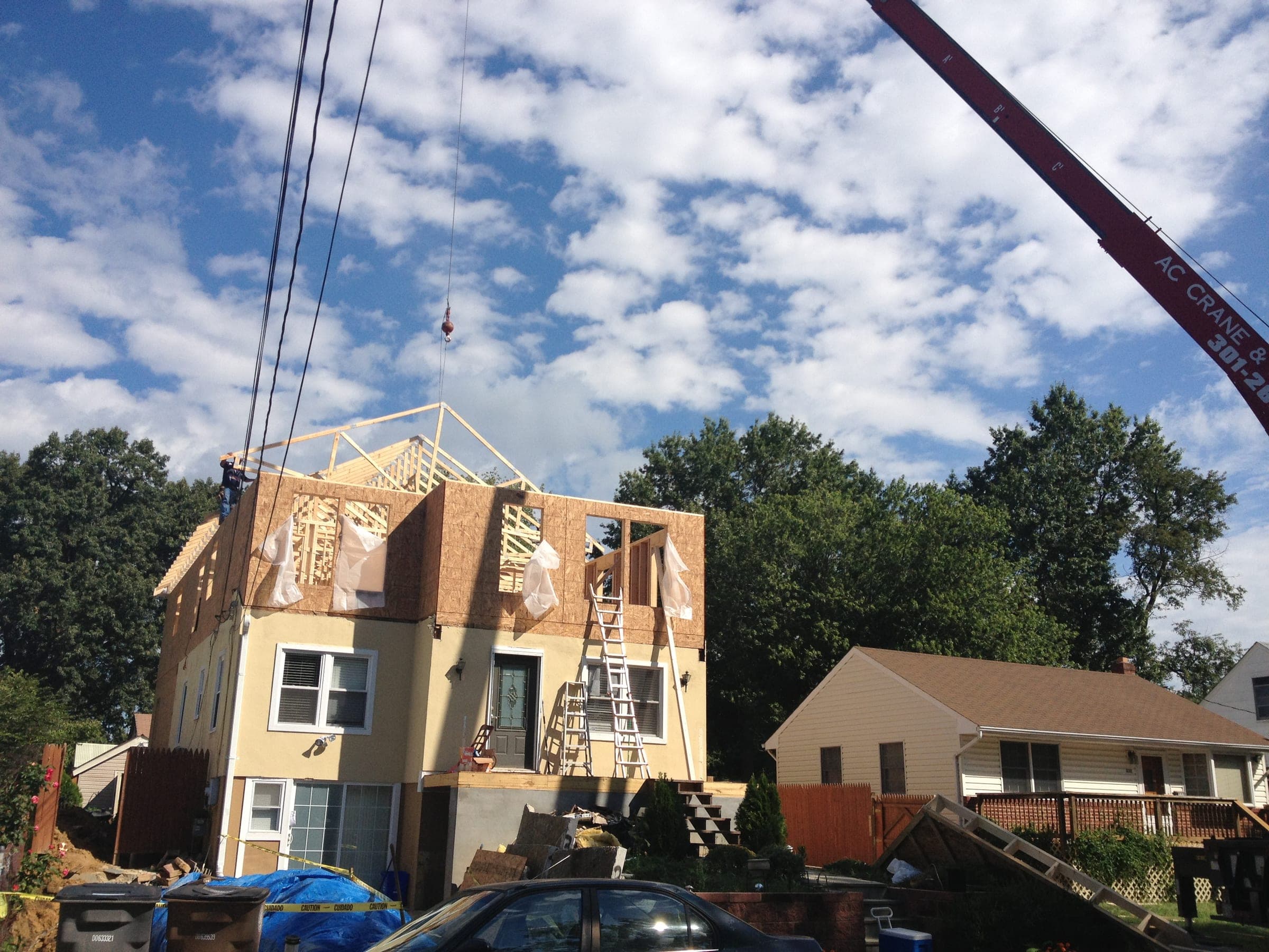 Second-story addition in progress, crane lifting the roof structure